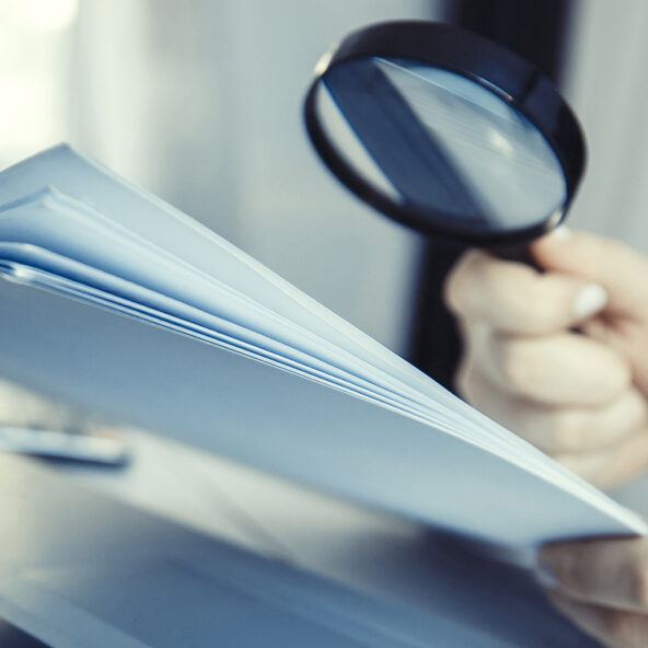 person using a magnifying glass to view document