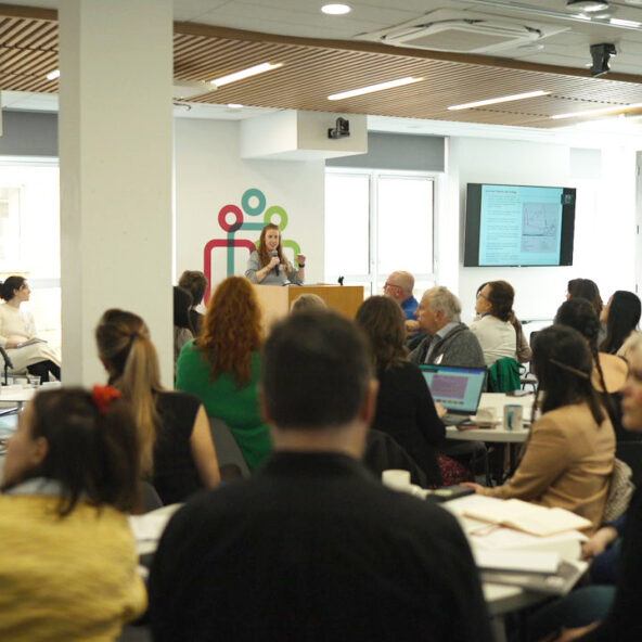 People sitting around round tables in IHREC event space